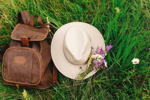 Şapka ve sırt çantası ve kır çiçekleri — Stok fotoğraf