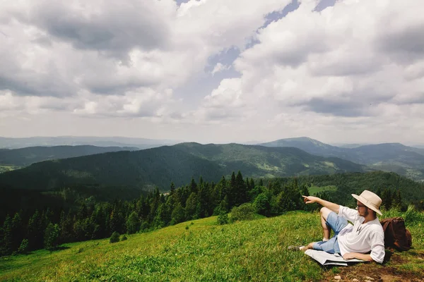 Viaggiatore hipster seduto in cima alle montagne — Foto Stock