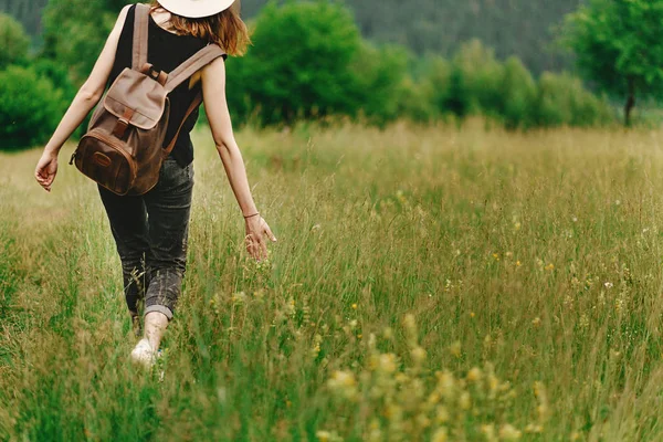 hipster woman walking in grass