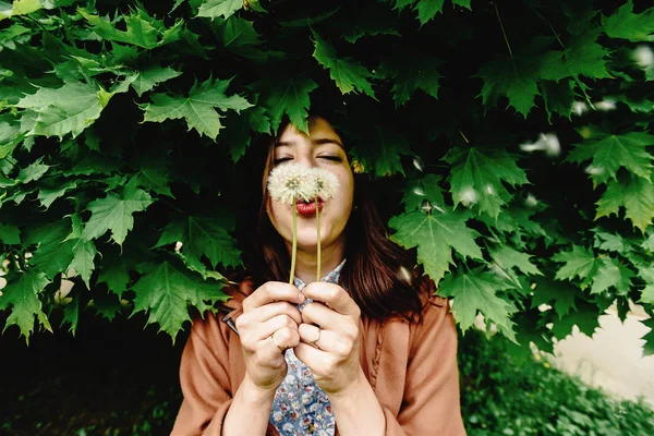 Hipster girl holding dandelion — Stock Photo, Image