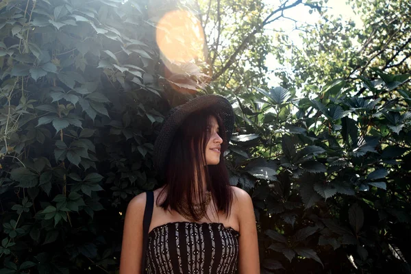 Woman hipster standing at green leaves — Stock Photo, Image