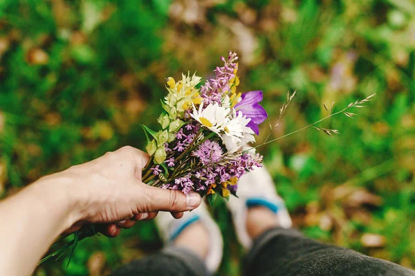Femme tenant des fleurs sauvages à la main — Photo