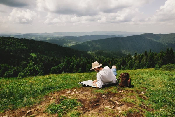 时髦旅行者坐在山的顶部 — 图库照片
