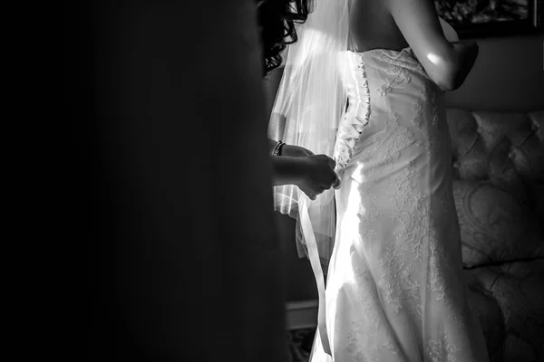 Bruidsmeisjes helpen krijgen gekleed bruid — Stockfoto