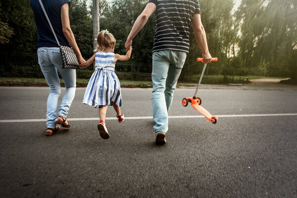 parents holding hands with daughter 