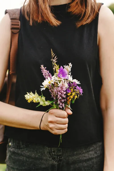 Mujer sosteniendo flores silvestres en la mano — Foto de Stock