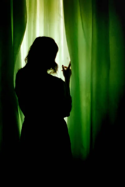 Woman standing at green curtains — Stock Photo, Image