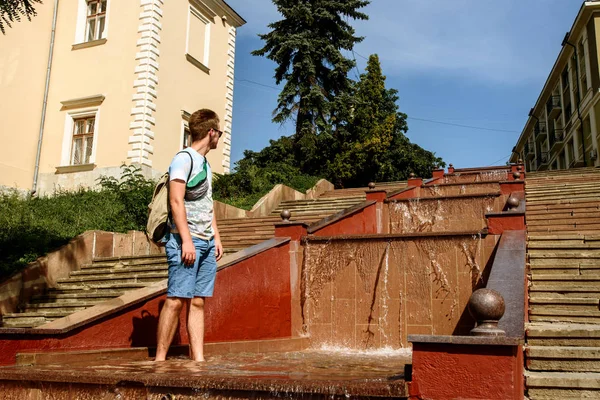Человек играет с водой в фонтане — стоковое фото