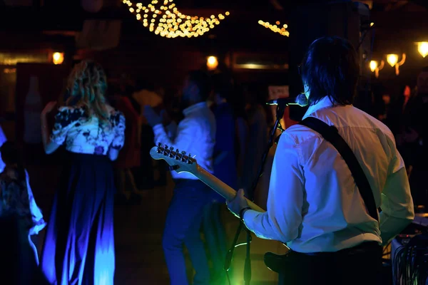 Stylish guitarist singing on a stage — Stock Photo, Image