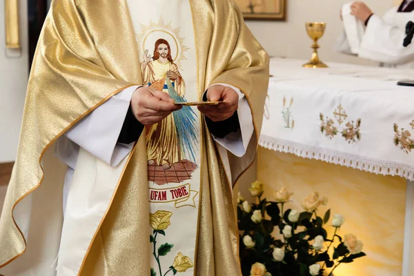 Priest holding golden plate — Stock Photo, Image