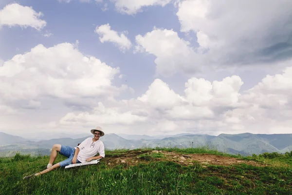 Reiziger van de Hipster zit op top van bergen — Stockfoto