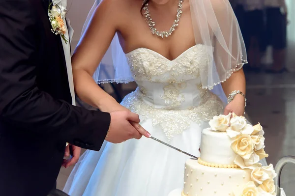 Braut und Bräutigam schneiden Hochzeitstorte — Stockfoto