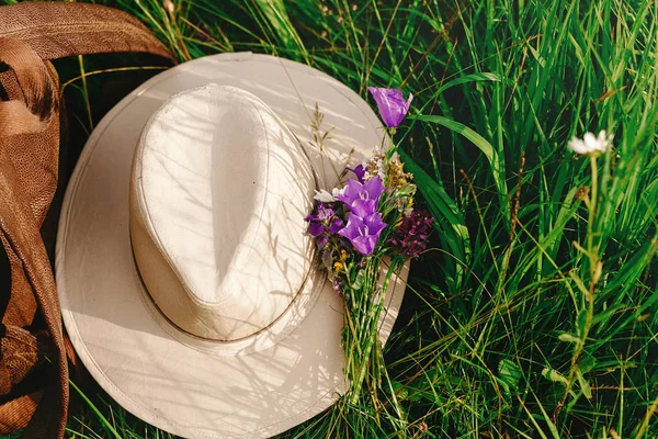 หมวกและกระเป๋าเป้และดอกไม้ป่า — ภาพถ่ายสต็อก