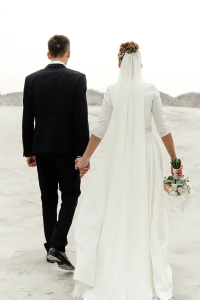 Νύφη και γαμπρός περπάτημα πιασμένοι χέρι χέρι — Φωτογραφία Αρχείου
