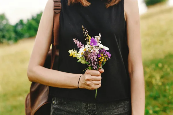 Vadvirágok a kezében tartó női — Stock Fotó