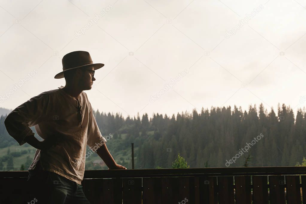 hipster man standing on porch 