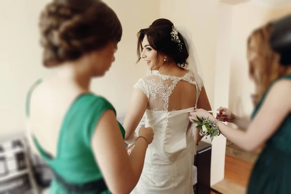 Družičky pomáhají bruneta nevěsta — Stock fotografie