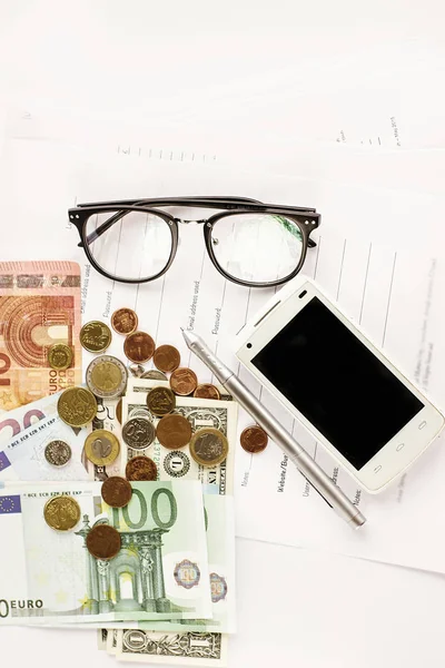 Geld, telefoon, rekenmachine en pen — Stockfoto