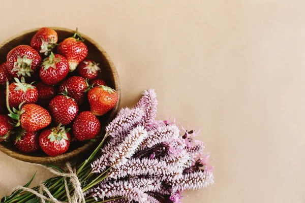 Fresas frescas y flores rosadas — Foto de Stock