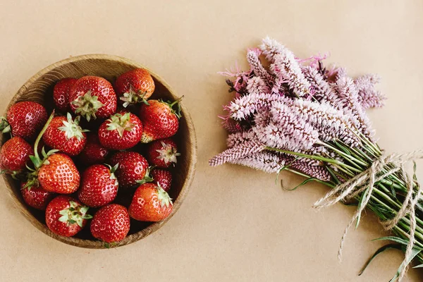 Fresas frescas y flores rosadas — Foto de Stock
