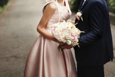 Gelin ve damat el ele tutuşuyorlar.