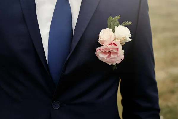 Corsages op bruidegom kostuum van roze rozen — Stockfoto