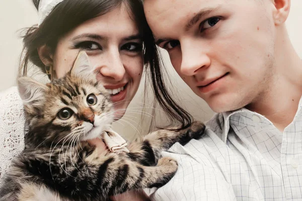 Hermosa pareja con lindo divertido gatito —  Fotos de Stock
