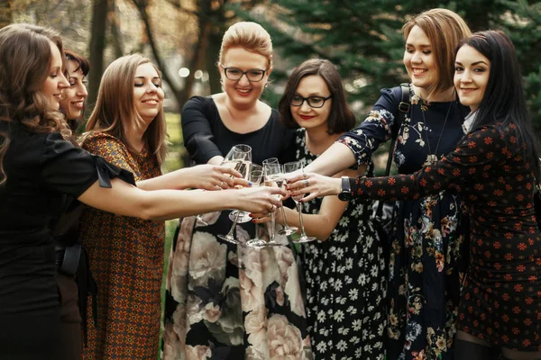 Группа роскошных элегантных женщин, празднующих и кликающих с чамом — стоковое фото