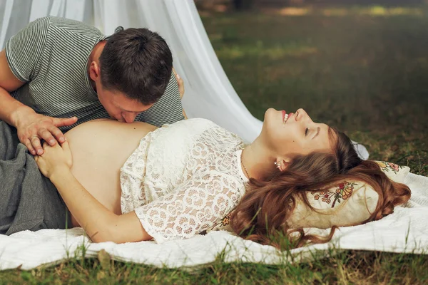 Marido beijando barriga da esposa grávida — Fotografia de Stock