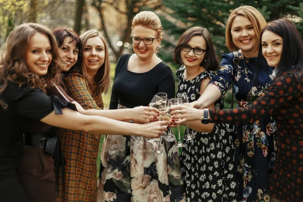 Группа роскошных элегантных женщин, празднующих и кликающих с чамом — стоковое фото
