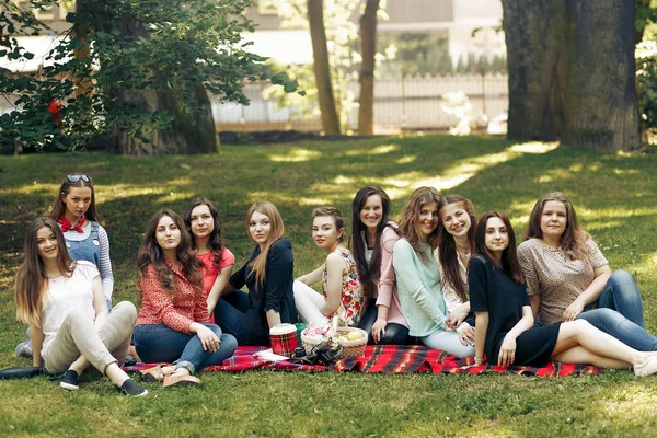 Meninas sentadas em cobertor no parque — Fotografia de Stock