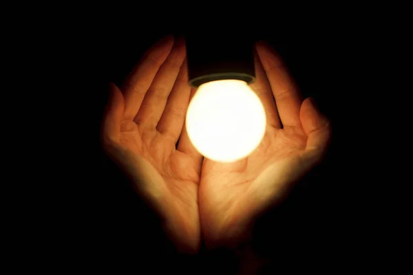 Hands holding illuminated led bulb Stock Image