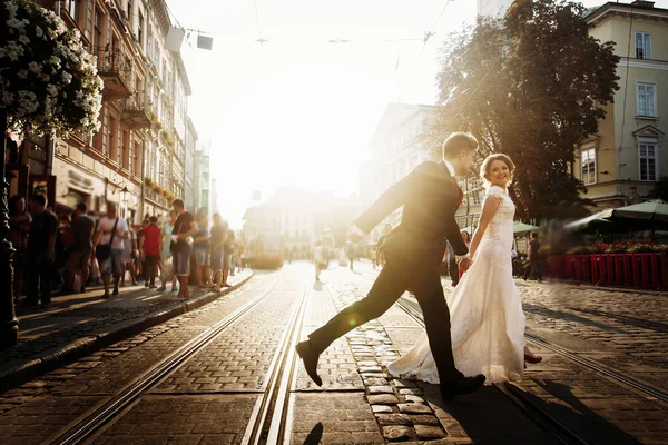 Divertido casal recém-casado correndo — Fotografia de Stock