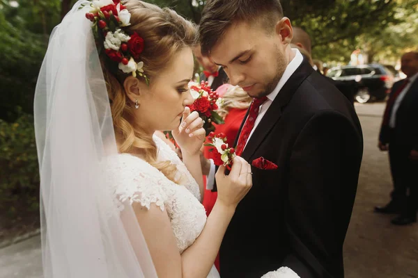 Невеста кладет бутоньерку на жениха — стоковое фото