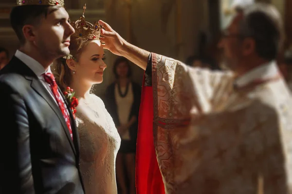 Mariée et marié portant des couronnes — Photo