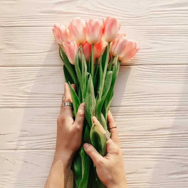 Handen met roze tulpen — Stockfoto