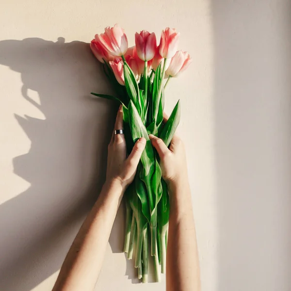 Mãos segurando tulipas rosa — Fotografia de Stock