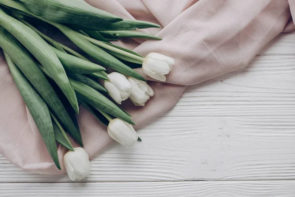 Bílé tulipány a béžová jemná tkanina — Stock fotografie