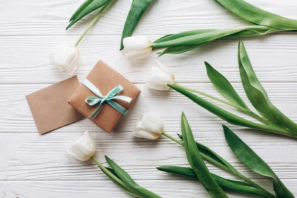 Caja de regalo, tarjeta y tulipanes — Foto de Stock