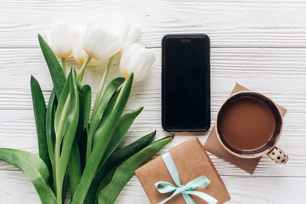 Regalo, teléfono, tulipanes y café — Foto de Stock
