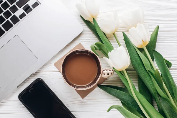 Phone screen, laptop, coffee and tulips — Stock Photo, Image