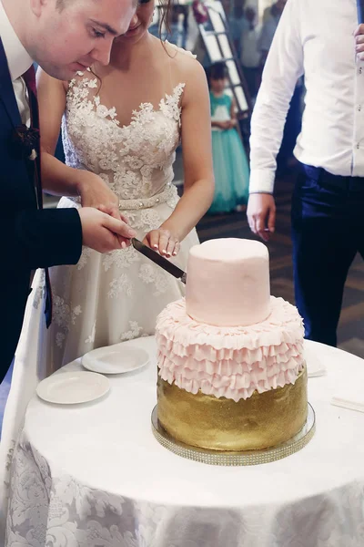 Νεόνυμφο ζευγάρι κοπής γαμήλια τούρτα — Φωτογραφία Αρχείου