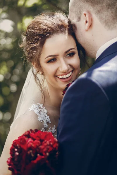 Lycklig nygift par kramar utomhus, porträtt av brudgummen kissin — Stockfoto