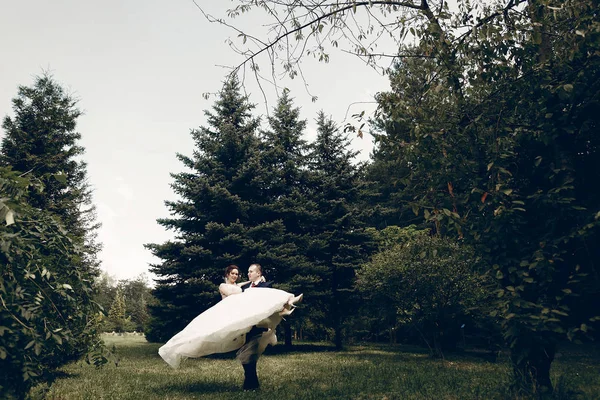Жених держит невесту в воздухе — стоковое фото