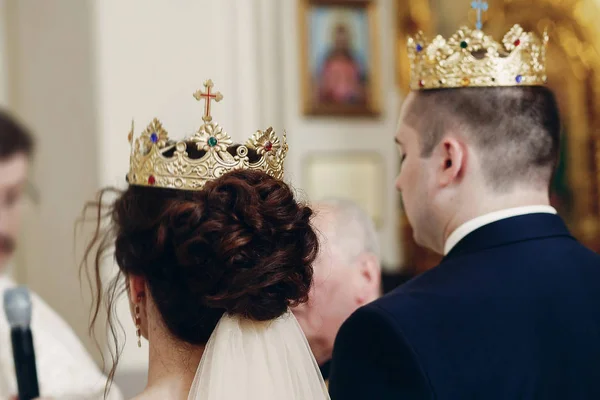 Bruden och brudgummen bär guldkronor — Stockfoto