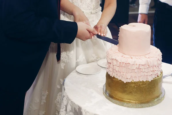 Молодая пара режет свадебный торт — стоковое фото