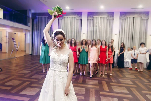 Braut wirft Brautjungfern Strauß zu — Stockfoto