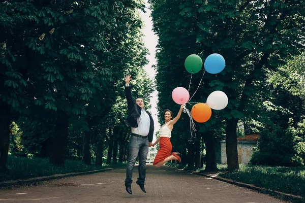 Diversión recién casada pareja saltando en el aire, novio guapo feliz y — Foto de Stock