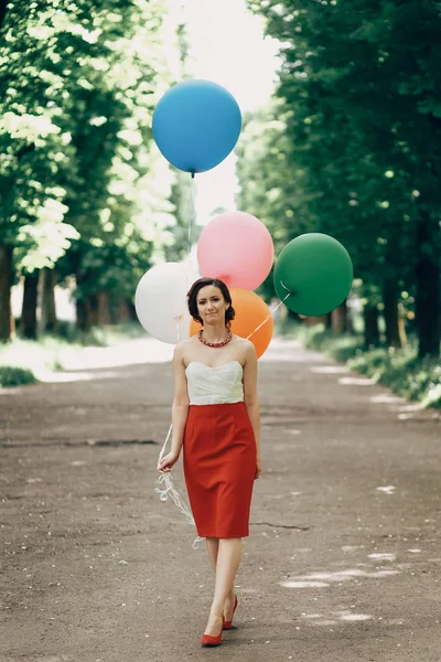 Brünette Frau mit bunten Luftballons — Stockfoto