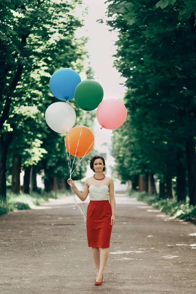 Brunette vrouw bedrijf kleurrijke ballonnen — Stockfoto